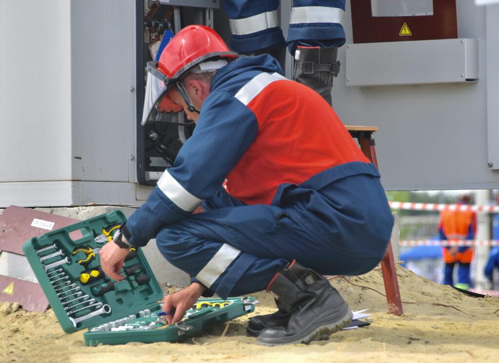 Image représentant un technicien effectuant des travaux de maintenance sur un appareil électrique.